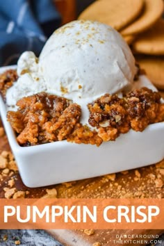 a scoop of ice cream sits in a white dish with pumpkin crisp on top