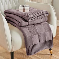 a chair with two blankets and a present on it