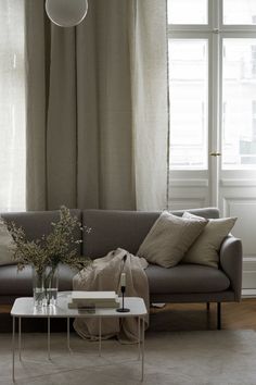 a living room with a couch, coffee table and large window in the back ground