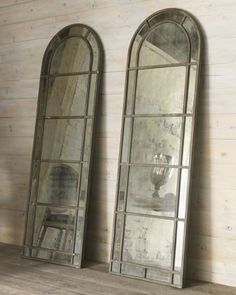 three mirrors sitting next to each other on top of a wooden floor in front of a wall