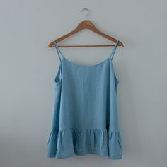 a blue top hanging on a wooden hanger