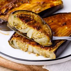 an eggplant dish is served on a white plate