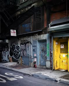 an alleyway with graffiti on the walls and doors