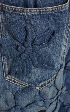 the back pocket of a pair of jeans with ruffles and buttons on them