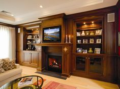 a living room filled with furniture and a flat screen tv mounted on a wall above a fire place