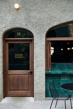 a table and chairs sitting in front of a building with two doors on each side