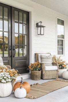 front porch decorated for fall with white pumpkins and flowers