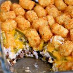 a casserole dish with tater tots and cheese on top, ready to be eaten