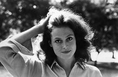 a woman is posing for a black and white photo with her hands on her head