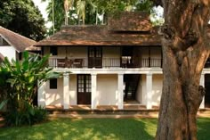 a white house with brown shutters and trees