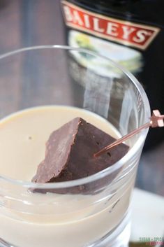 a glass filled with milk and chocolate on top of a table