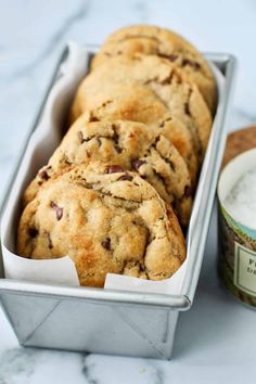 chocolate chip cookies in a tin next to a can of ice cream