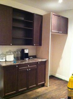 a kitchen with brown cabinets and wood floors in the process of remodeling