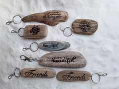 five wooden keychains with sayings on them sitting next to each other in front of a white sheet