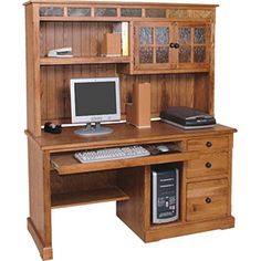 a wooden desk with a computer monitor and keyboard