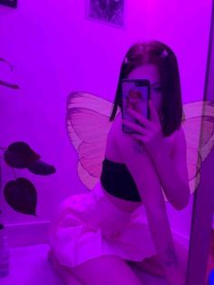 a woman taking a selfie in front of a mirror with a butterfly on it