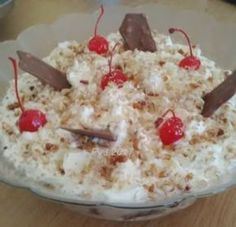 a cake with white frosting and cherries is on a plate, ready to be eaten