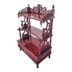 a wooden shelf with ornate carvings on the top and bottom, sitting against a white background