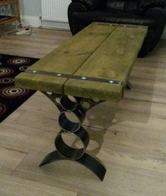 a wooden bench sitting on top of a hard wood floor next to a black chair