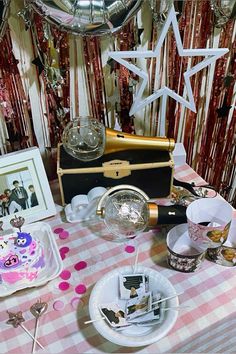 a table topped with plates and confetti next to a cake