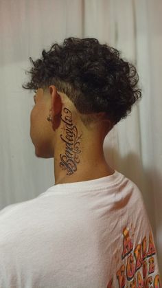 the back of a woman's head with tattoos on her upper and lower neck