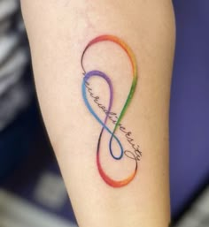 a tattoo on the leg of a woman with an infinite love symbol in rainbow colors