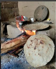 two pita breads cooking over an open fire