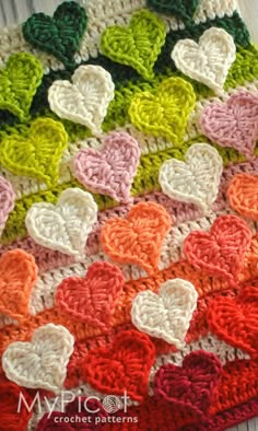 a crocheted blanket with many hearts on the front and back, all in different colors