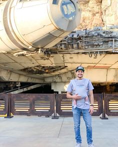 a man holding a baby in front of a star wars vehicle at disney's hollywood studios