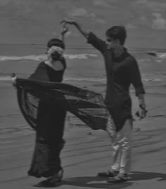 black and white photograph of two people on the beach