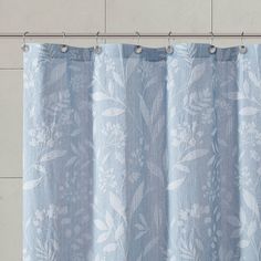 a blue curtain hanging on the side of a wall next to a white tile floor