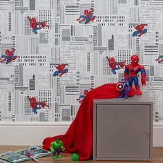 spiderman wallpaper in a children's room with toy figures on the dresser