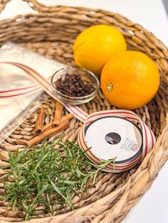 two oranges sitting in a wicker basket next to some spices and other items