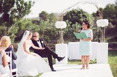 a bride and groom are sitting at the alter as they read their vows to each other