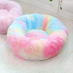 two pastel colored pet beds on the floor