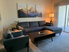 a living room with two couches and a coffee table in front of a sliding glass door