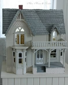 a white doll house sitting on top of a table