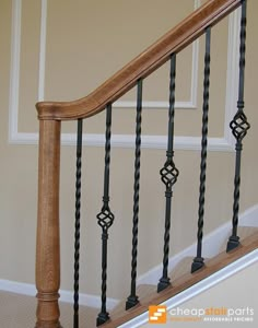 a wooden banister next to a white wall and carpeted flooring in a home