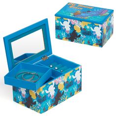 an open jewelry box sitting on top of a white table next to a blue box