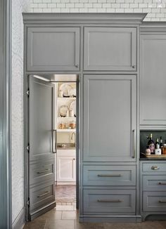 an open door leading to a kitchen with gray cabinets