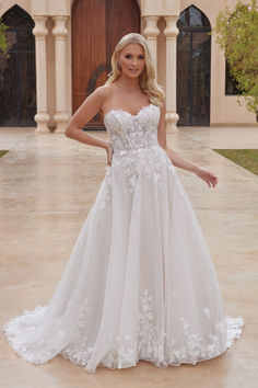 a woman standing in front of a building wearing a wedding dress