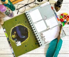 an open notebook sitting on top of a wooden table next to a pair of glasses