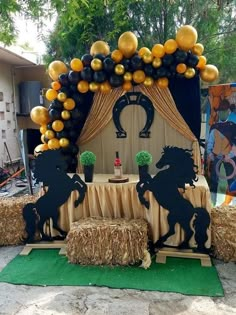 a horse themed party with hay bales and balloons