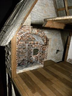 an old brick fireplace in the corner of a room with wooden floors and walls,