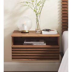 a nightstand with flowers and books on it