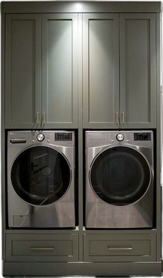 two washers and dryer in front of gray cabinets