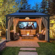 an outdoor movie theater in the middle of a yard with chairs and couches around it