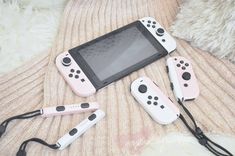 four nintendo wii game controllers sitting next to each other on top of a bed with cords