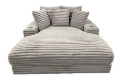 a large gray couch with five pillows on it's back and two side ends