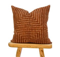 a brown pillow sitting on top of a wooden chair